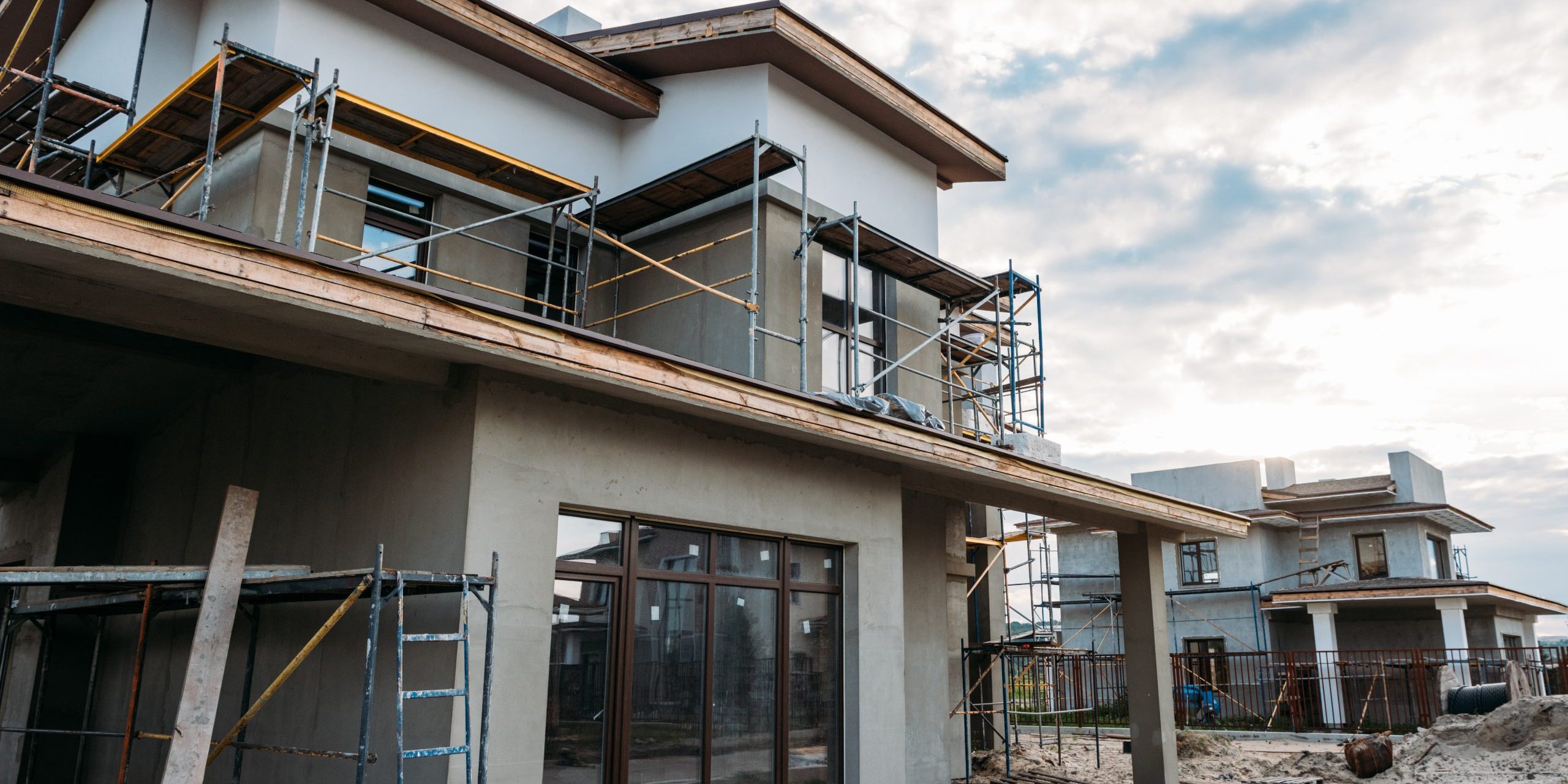 close-up shot of contemporary building construction with scaffolding under cloudy sky