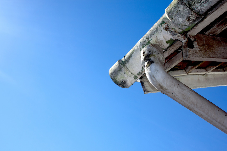 Upward View Of Mouldy Asbestos Guttering And Downpipe